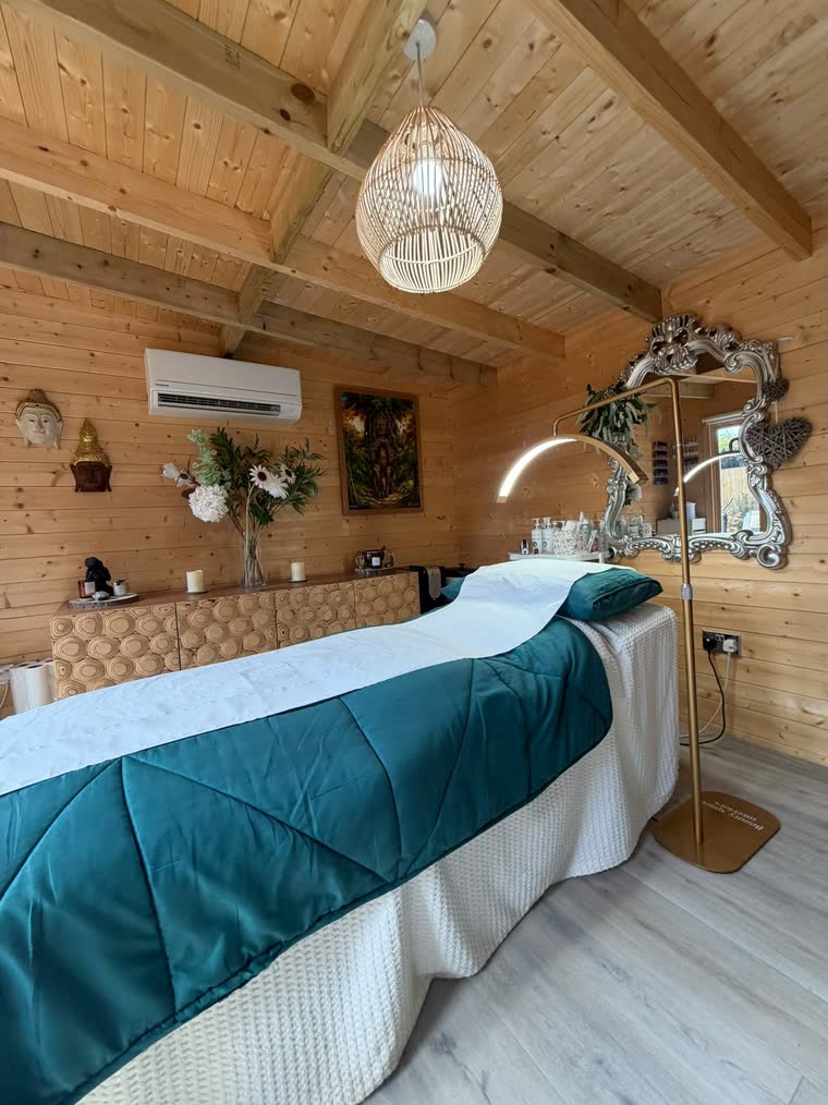 The treatment bed made up in teal and cream under soft warm light