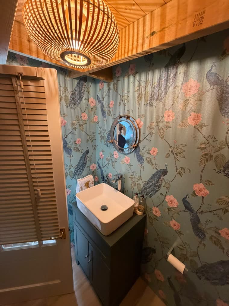 The cabin's own bathroom, with a round porthole window above the sink